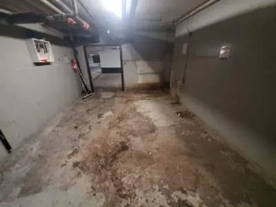 Garbage room floor before WasteMind's epoxy retrofit, stained and damaged